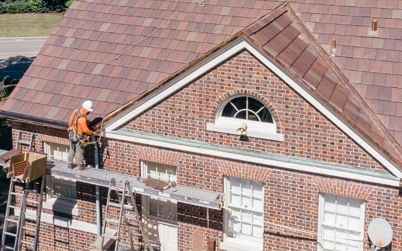 aerial photo of baker employee on scaffolding installing copper gutters