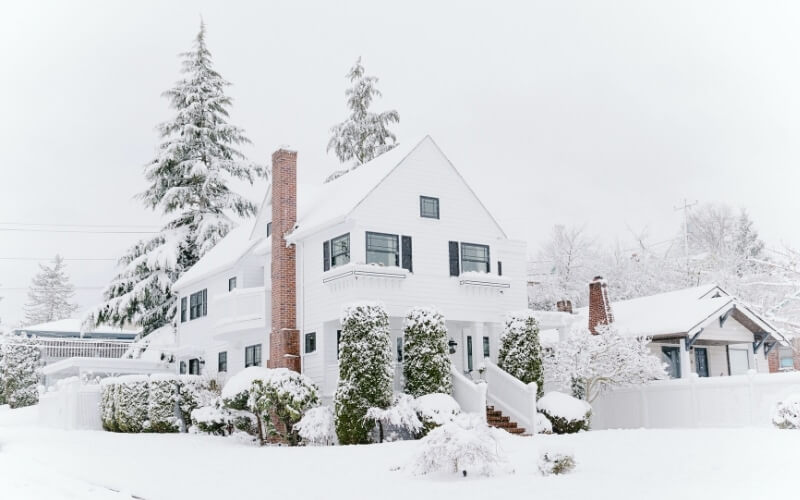 photo of a house from the street covered in white snow