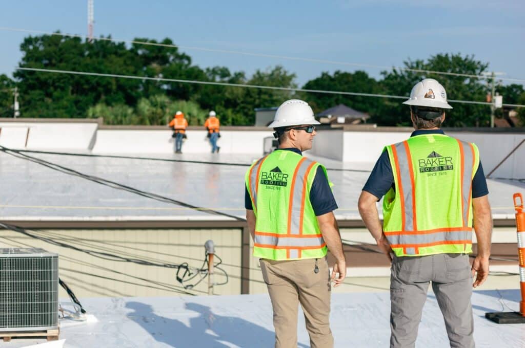 two baker employees in safety on a TPO roof