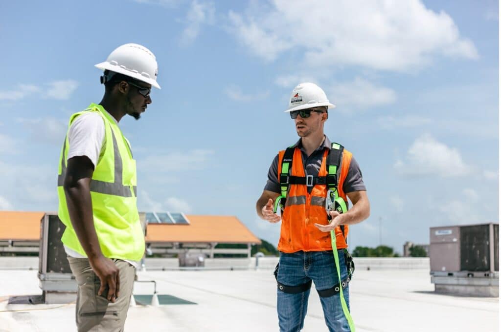 two guys talking about work on a TPO roof