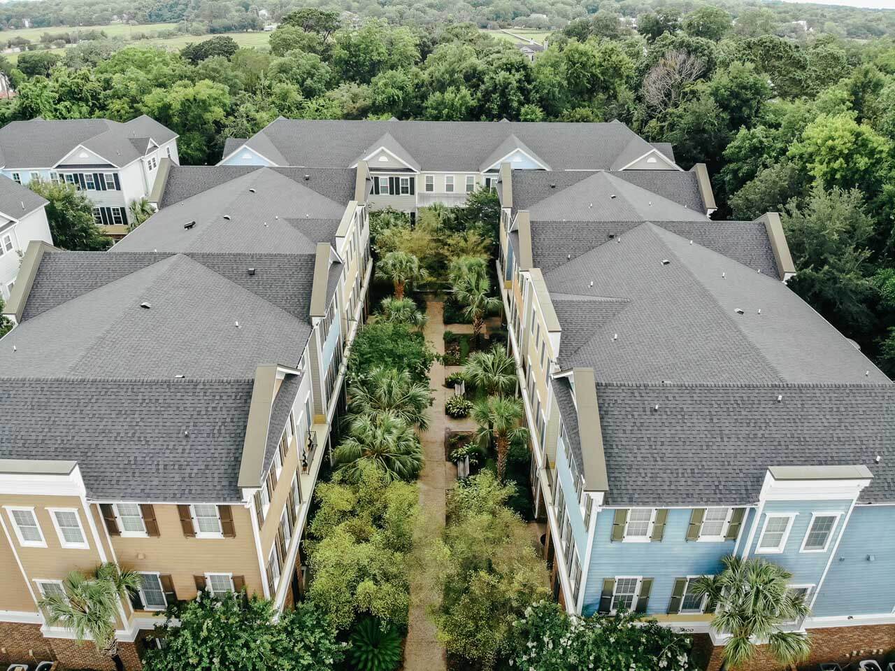 Aerial view of a multi-family townhome complex with a gray shingle roof