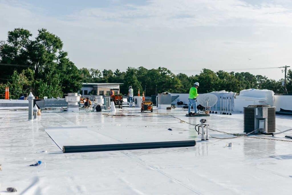 Roofers completing a roof replacement and installing a TPO membrane roof