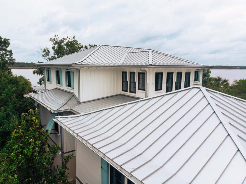 Aerial view of a silver metal panel roof on a waterfront house