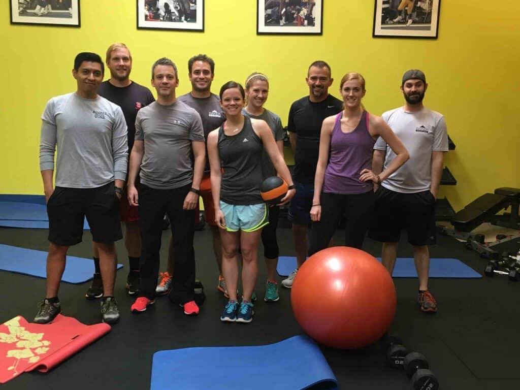 a group of people in an exercise room posing for a photo