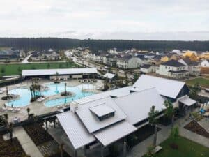 Aerial view of a neighborhood community clubhouse with a silver metal roof