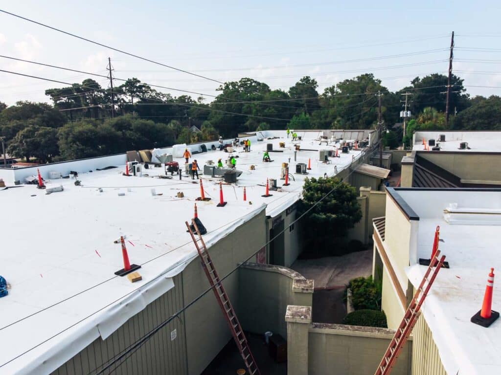 Aerial view of construction workers completing a TPO roof replacement