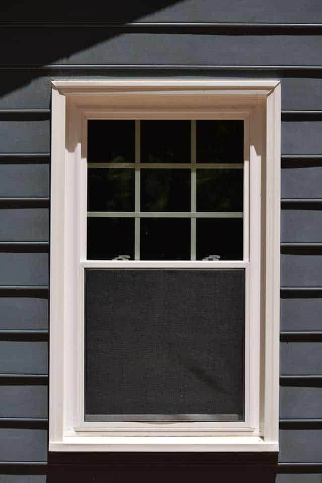 Dark blue fiber cement house siding and white window
