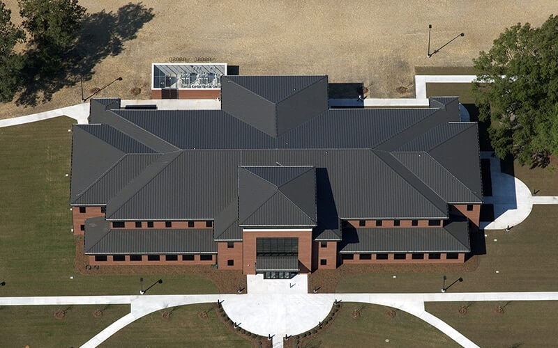 Aerial view of a brick building with a black metal roof