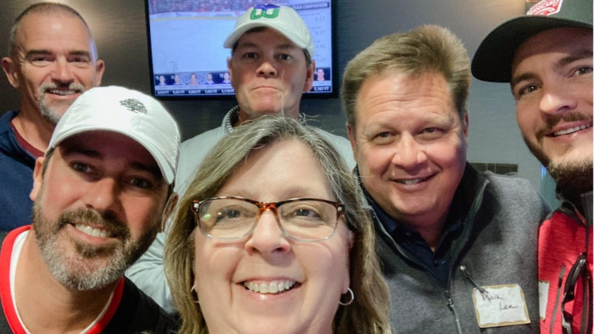 leadership and employees at a hurricane game celebration selfie