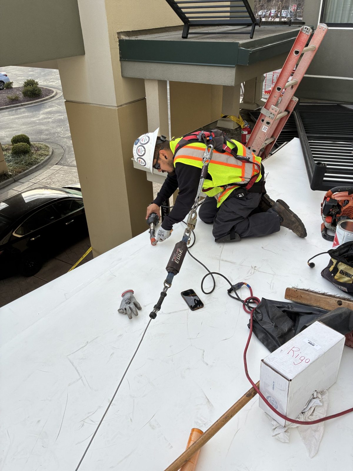 guy on roof doing single ply roof replacement