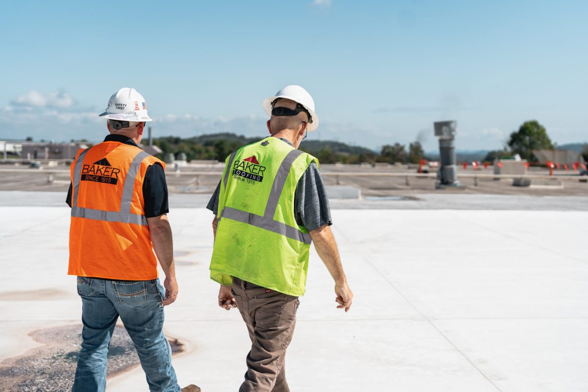two men with safety walking and reviewing roof work