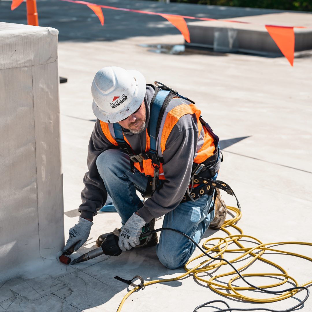 man tied off working on hvac unit roofer