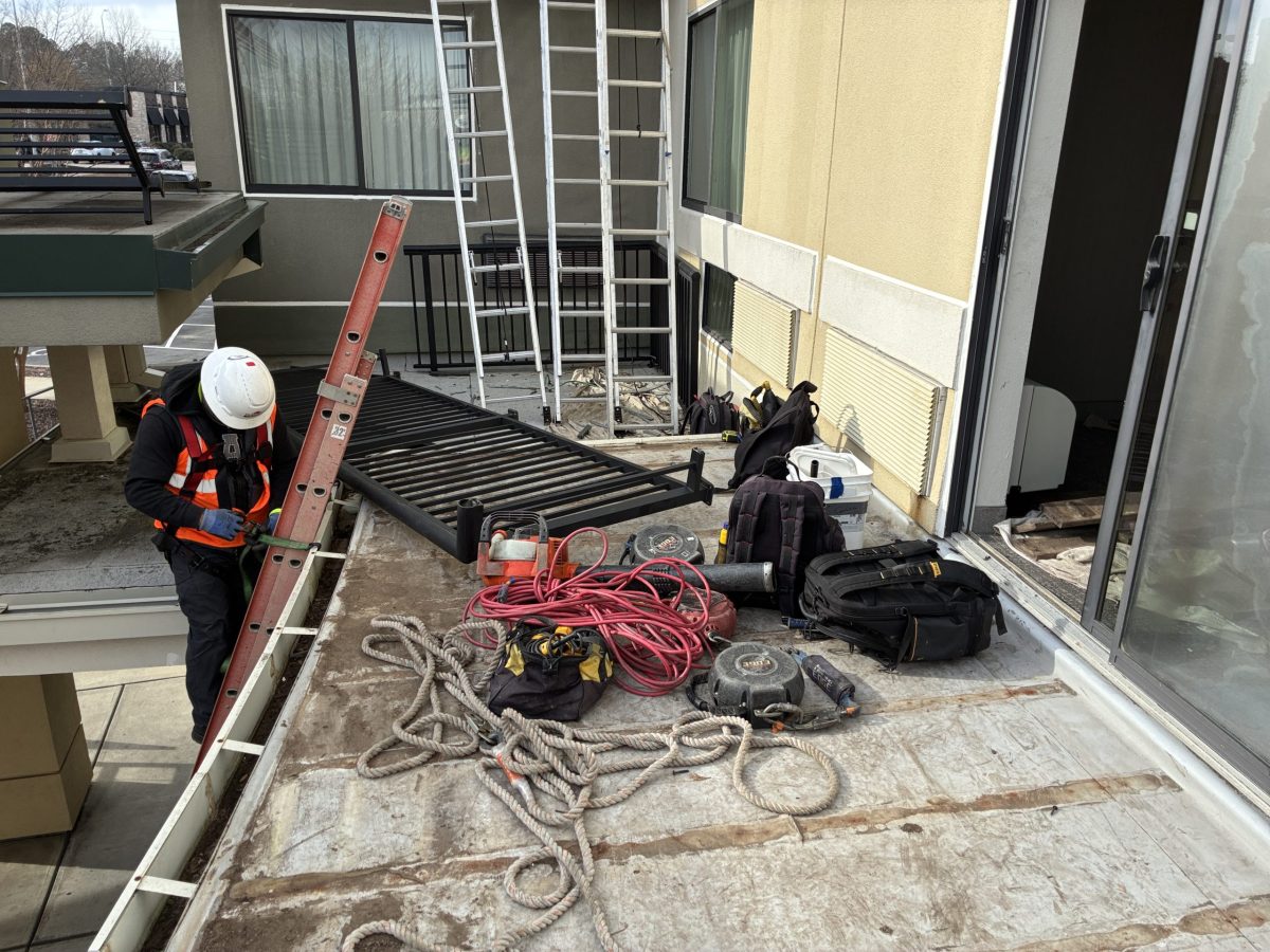 guy on roof doing single ply roof replacement