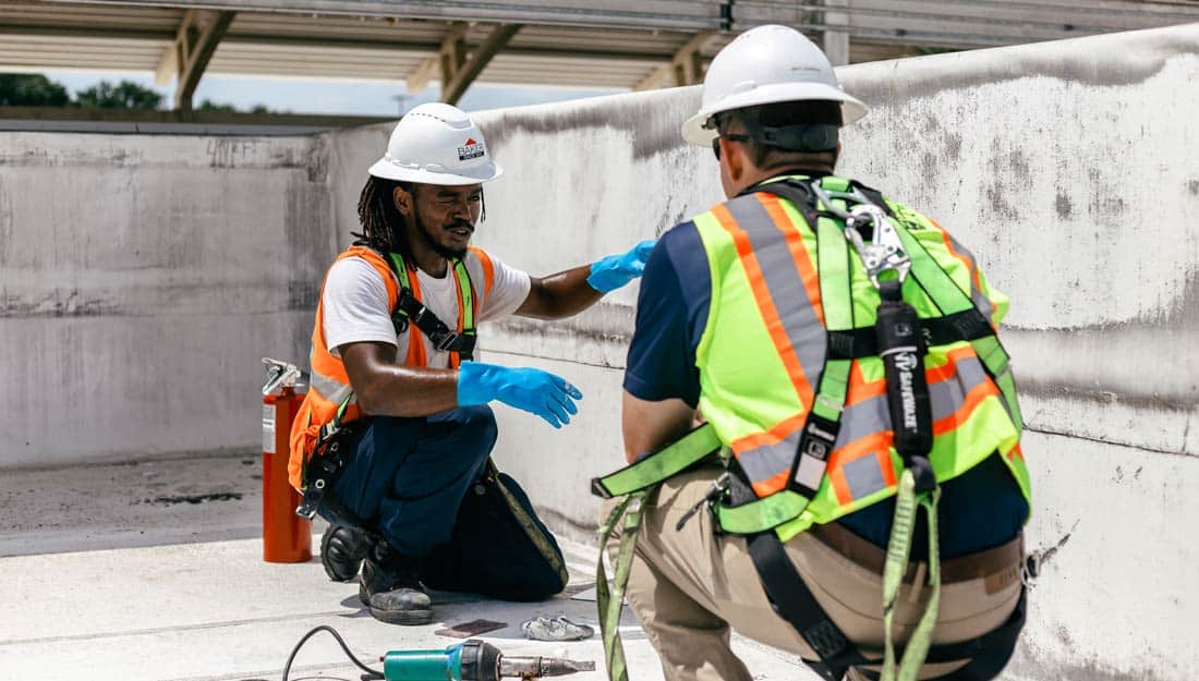 two crew members working on roof