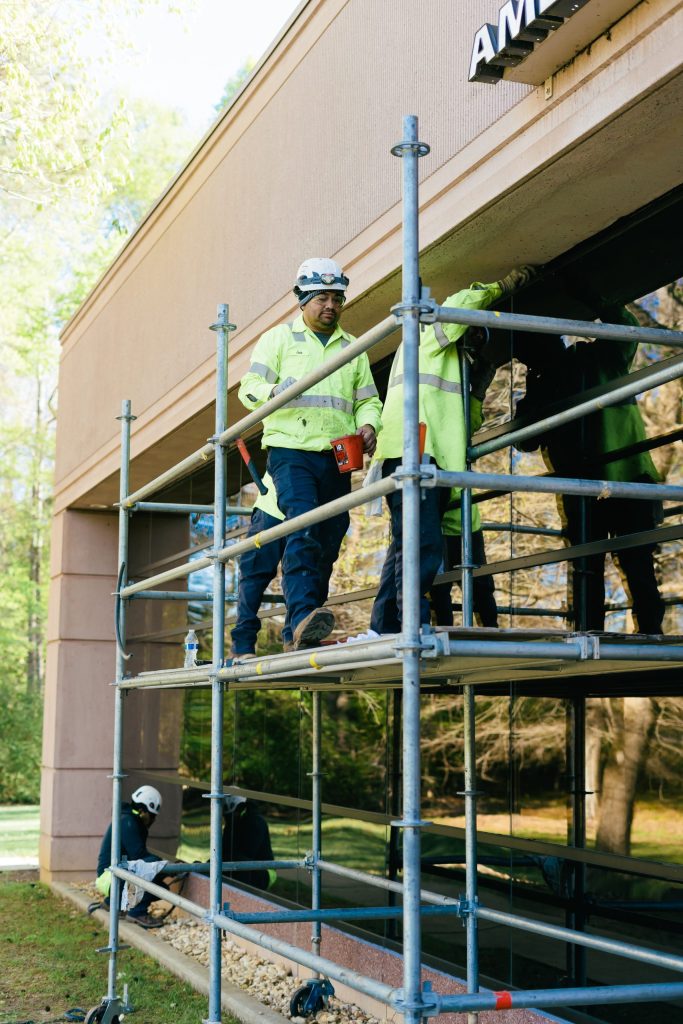 men repairing window of office building