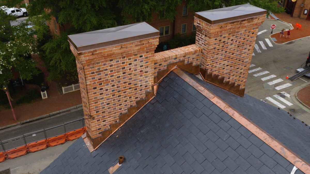 Copper step flashing and chimney caps on the natural slate roof of Gates Hall at William & Mary in Williamsburg, VA