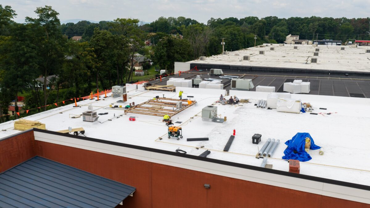 Crew installing TPO membrane over polyiso insulation at Boot Barn in Lynchburg, VA