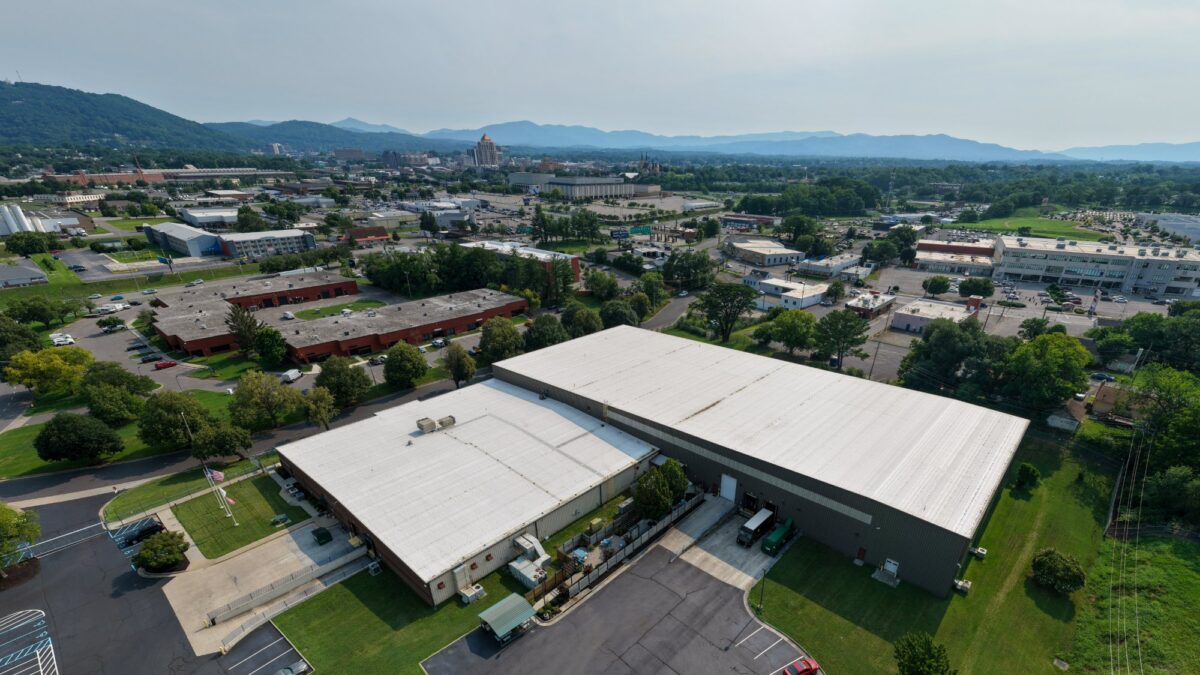 Wide aerial of Foot Levelers' Roanoke, VA facility showing the TPO roof retrofit with downtown Roanoke in the background