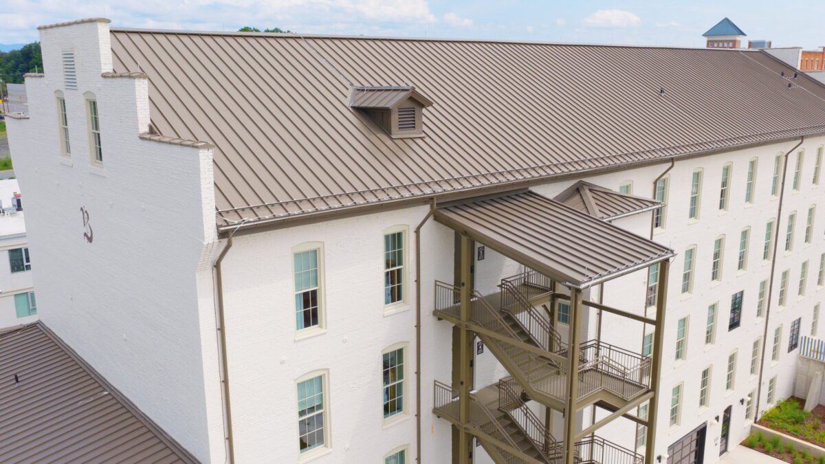 Pre-weathered Galvalume standing seam metal roof, dormer and stair canopy on The Balladeer Hotel in Mount Airy, NC
